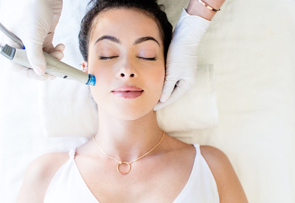 woman relaxed with her eyes closed receiving a medical facial treatment