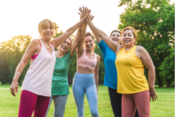 women in different color tops and high-fiving