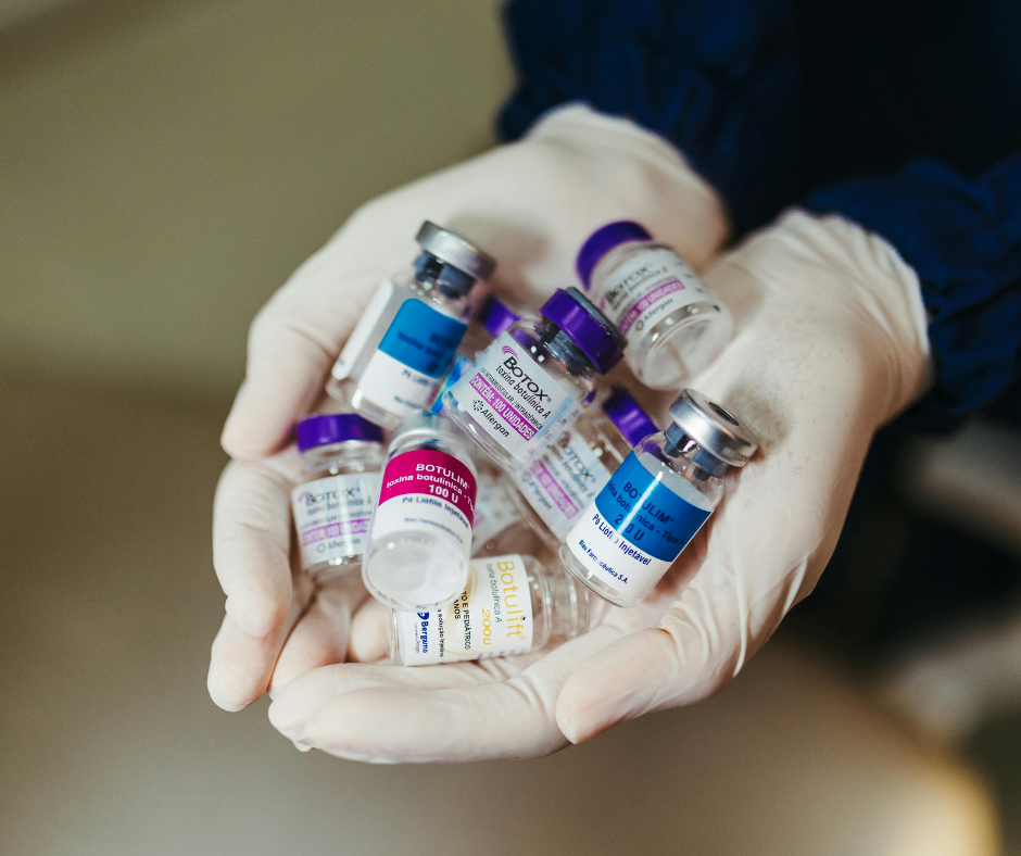 gloved hands hold a pile of neurotoxin vials. The one on top says Botox