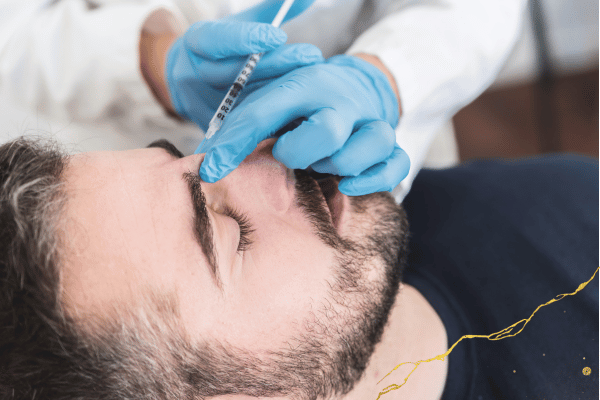 patient receives injection at the top of his nose.