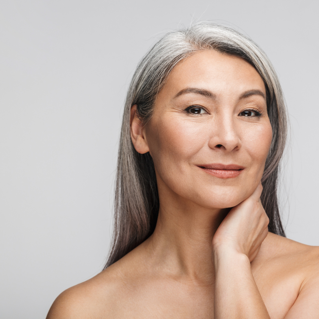 a middle age female with beautiful skin and long silver hair.